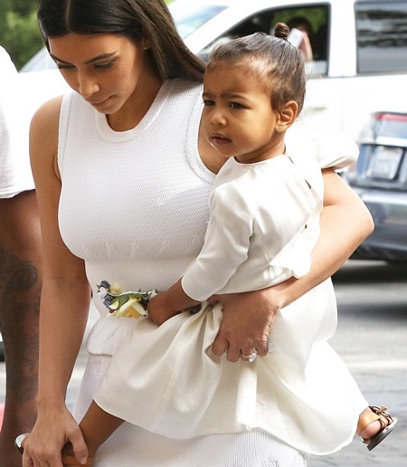 Đại gia đình Kardashian quây quần trong ngày Lễ Phục sinh - 4 Cô con gái của Kim ngoan ngoãn nằm yên trong vòng tay của mẹ khi cả nhà tiến vào trong nhà thờ.