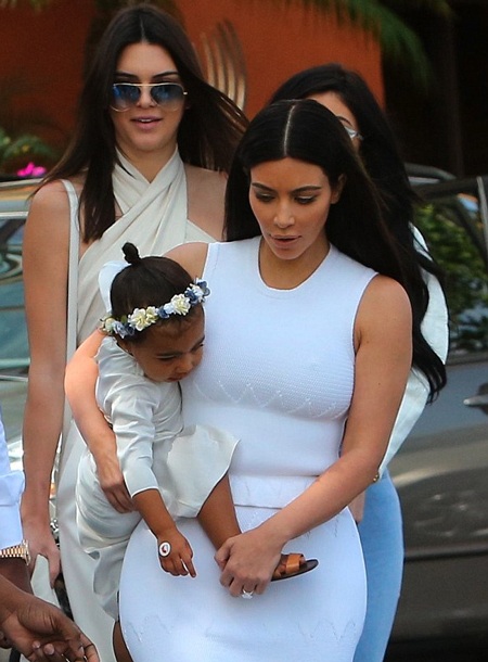 Đại gia đình Kardashian quây quần trong ngày Lễ Phục sinh - 5 Cô con gái của Kim ngoan ngoãn nằm yên trong vòng tay của mẹ khi cả nhà tiến vào trong nhà thờ.