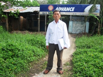 Ông Trung với tập hồ sơ thắng kiện trước căn nhà 568 Lê Lợi, thị trấn Mỹ Xuyên. Ảnh: Trúc Lâm