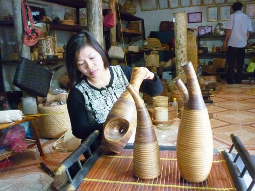 Nghệ nhân Nguyễn Thị Hân bên những mẫu sản phẩm độc đáo kết hợp giữa gốm và mây.