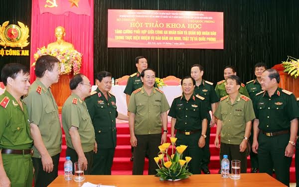 Sự đoàn kết giữa Công an và Quân đội là khởi nguồn sức mạnh của lực lượng vũ trang - 2 Bộ trưởng Trần Đại Quang (thứ tư từ phải sang) trao đổi với các đại biểu bên lề hội thảo