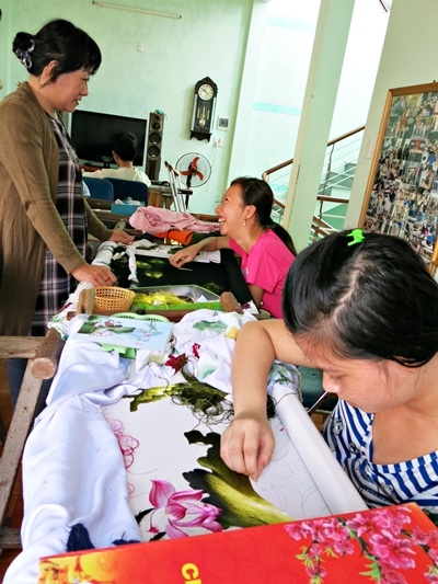 Chị Liền bên “các con” ở cơ sở dạy nghề tranh thêu cho trẻ khuyết tật Thanh Ngọc Minh