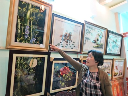 Chị Liền tự hào khoe những tác phẩm tranh thêu đẹp của học trò.