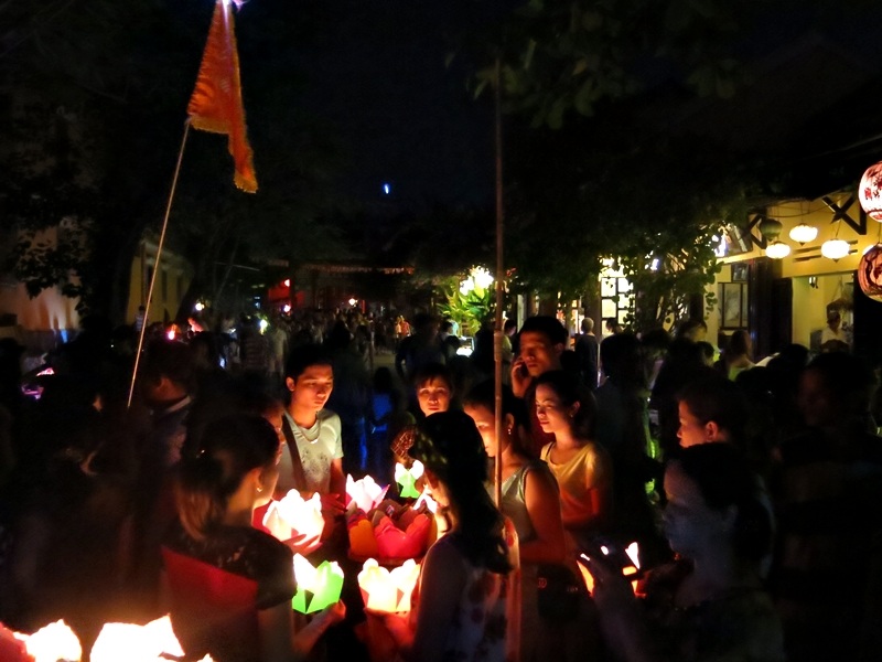 Người dân và du khách mang theo hoa đăng dạo phố không ánh đèn điện