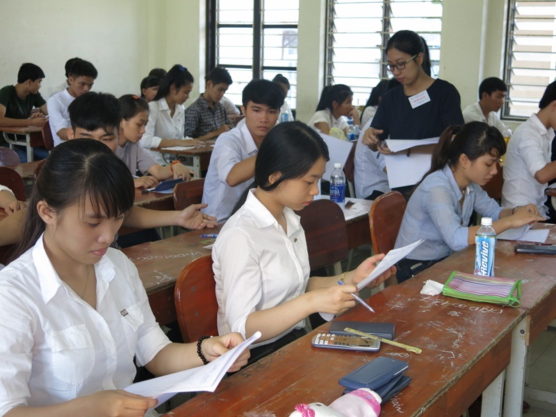 Giám thị phát giấy làm bài thi môn Toán cho thí sinh. (Ảnh: Khánh Hiền)