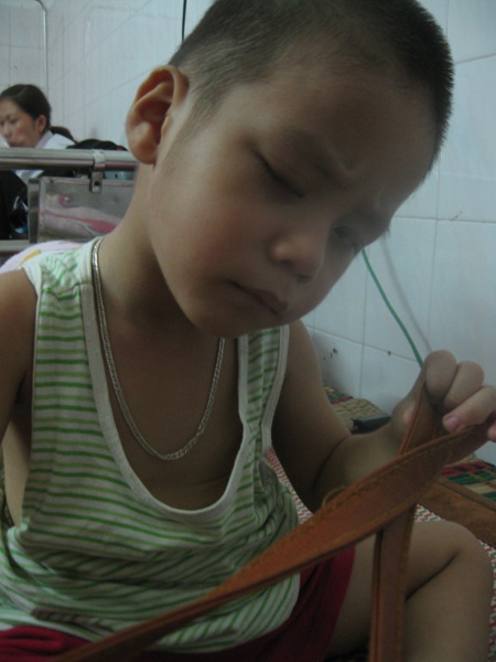 Bị bong võng mạc, mắt trái của Sơn chỉ còn thấy mờ mờ nên em phải dí sát vật vào mắt mới thấy