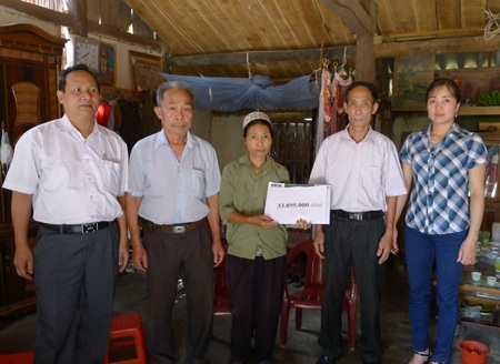 Bà Lẫy cùng chính quyền địa phương nhận món quà của bạn đọc Dân trí