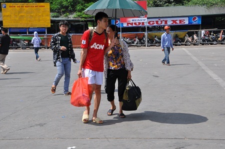 Hai mẹ con tay xách, nách mang hành lí về nhà.