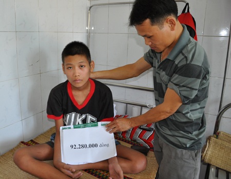 Hai bố con anh Huynh nhận quà bạn đọc Dân trí.