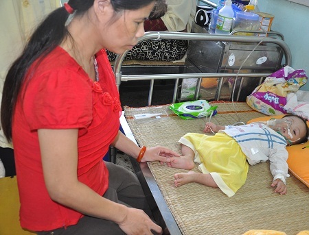 Mắt không nhìn thấy gì nhưng ở bệnh viện chị Xinh vẫn muốn chăm sóc con.