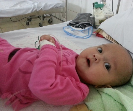 Gương mặt đáng yêu của con tỏ vẻ thích thú khi được mặc quần áo mới của các bác cho.