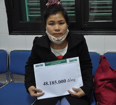 Chị Long nhận tiền của bạn đọc Dân trí giúp đỡ tại bệnh viện Việt Đức.