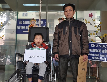 Hai bố con bé Minh nhận quà bạn đọc Dân trí tại khoa Phẫu thuật cột sống, BV Việt Đức.