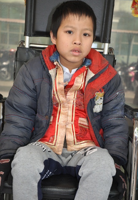 Hai bố con bé Minh nhận quà bạn đọc Dân trí tại khoa Phẫu thuật cột sống, BV Việt Đức.