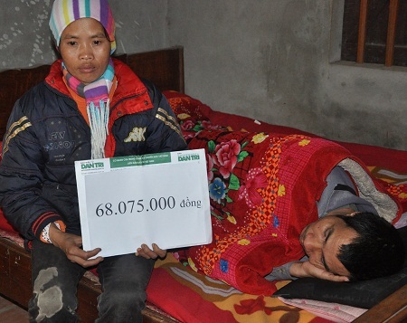 Thay mặt gia đình, chị Ngà nhận món quà bạn đọc Dân trí giúp đỡ.