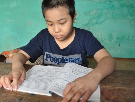 Sau mỗi đợt truyền hóa chất trở về nhà, cậu bé Tú lại lấy sách vở ra học.