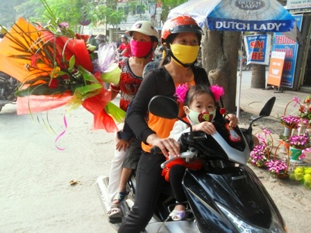 Các bậc phụ huynh chở con đến chúc mừng giáo viên của con. (Ảnh Hoàng Văn)