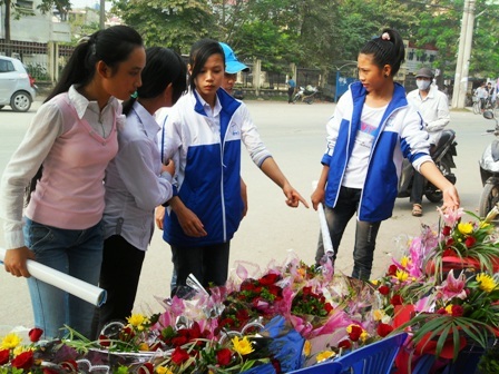 Các em học sinh đang chọn lựa những bó hoa tươi thắm để tặng thầy cô giáo. (Duy Tuyên)