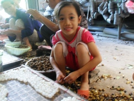 Em bé nhỏ tuổi rất cần mẫn và thích thú với công việc này.