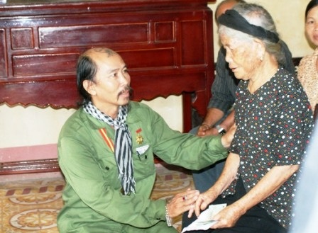 Nghễ sĩ Quang Đạt ân cần thăm hỏi sức khỏe của từng mẹ Việt Nam anh hùng.