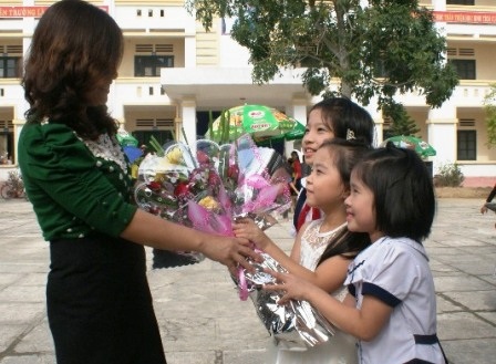 Cô Nguyễn Thị Hải - GV Trường tiểu học Lý Tự Trọng nhận hoa của các em học sinh (Ảnh: Thái Bá)