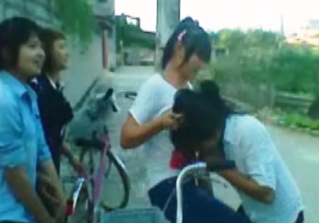 Một nữ sinh túm tóc và dùng gối thúc vào người em B