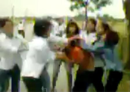 Cô gái mặc áo vàng bị nhóm nữ sinh mặc đồng phục vây đánh (ảnh cắt từ clip).