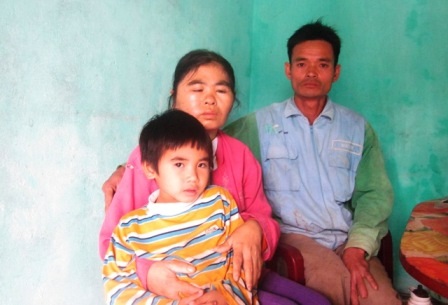 Vợ chồng anh Thủy chị Khương bên đứa con trai út trong căn nhà trống hoác.