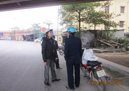 Cán bộ Thanh tra giao thông đang đút tay túi quần nói chuyện với người vi phạm.