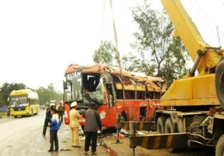 Chiếc xe khách bị lật đang được đội cứu hộ đưa đi