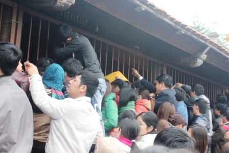 Bám cả lên thanh sắt cửa đền phát ấn.