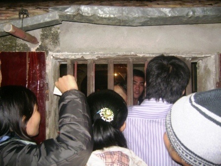 Nhiều người đứng bên cửa sổ đưa tiền vào bên trong để được lấy ấn ra ngoài.