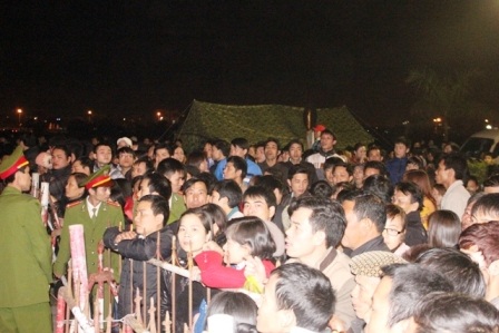 Chen chúc nhau đứng sau hàng rào bảo vệ.