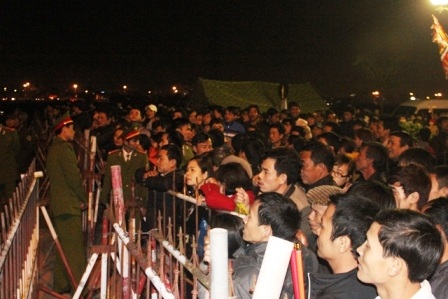 Chen chúc nhau đứng sau hàng rào bảo vệ.