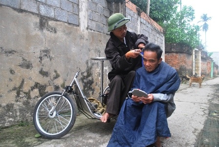  Anh Tý đang cắt tóc cho khách.