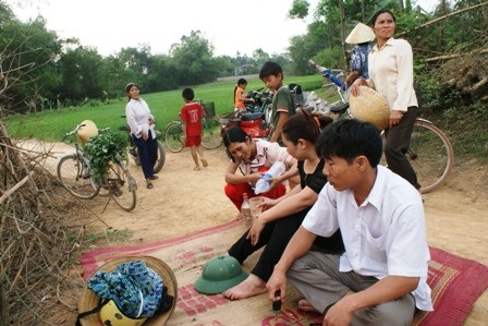 Nhiều người trải chiếu ngồi ngay ngoài đường gần khu vực giếng nước có con rắn.