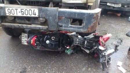 Chiếc xe máy nát bét dưới gầm xe tải