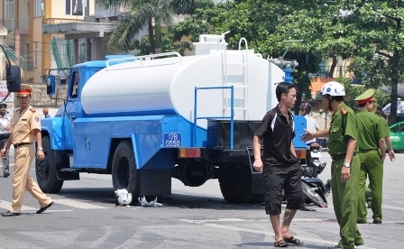 Xe chữa cháy mất phanh, 2 người thương vong - 1 Hai chiếc mũ bảo hiểm bị cán nát dưới bánh xe chở nước.