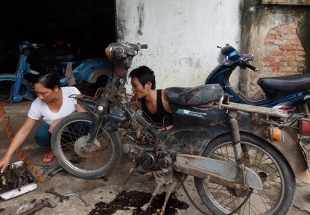 Hàng ngày, chị Lan phụ giúp chồng sửa xe máy.