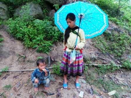  Một phụ nữ người Mông dẫn con đến khai giảng năm học mới.