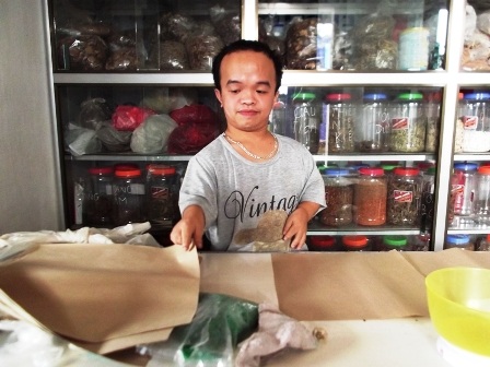 Thầy thuốc Đông y Ngô Văn Định đang bốc thuốc cho bệnh nhân.