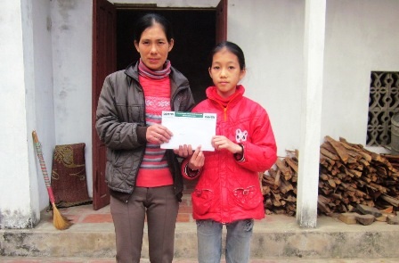 Chị Huyên đón nhận món quà của các nhà hảo tâm giúp đỡ gia đình chị.