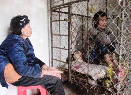  Em Trình Thị Xuân đang đưa nước cho bố mình qua khe của nhỏ vào bên trong chiếc lồng.