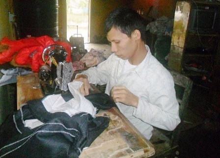 Sau mỗi buổi đi làm ở công ty, anh Trượng tranh thủ về nhà nhận cắt may quần áo kiếm thêm thu nhập.