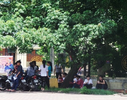 Ngồi gốc cây tránh nắng trước giờ thi.