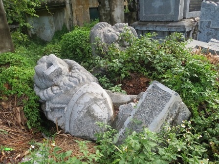 Sư tử đá phong cách châu Âu bị bỏ lăn lóc ngoài bờ bụi.