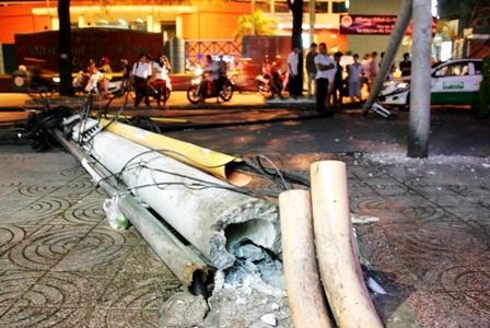 Trụ điện gãy kéo đổ cột đèn, đè vào taxi - 1
