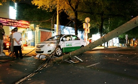 Trụ điện gãy kéo đổ cột đèn, đè vào taxi - 2