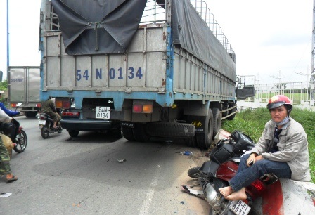 Một nạn nhân thoát chết máy mắn, ngồi thẫn thờ bên chiếc xe
vỡ vụn