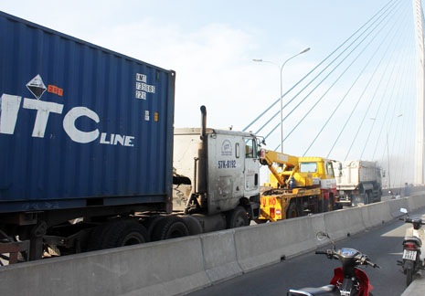 Xe cứu hộ, xe ben được huy động kéo chiếc container ra khỏi cầu